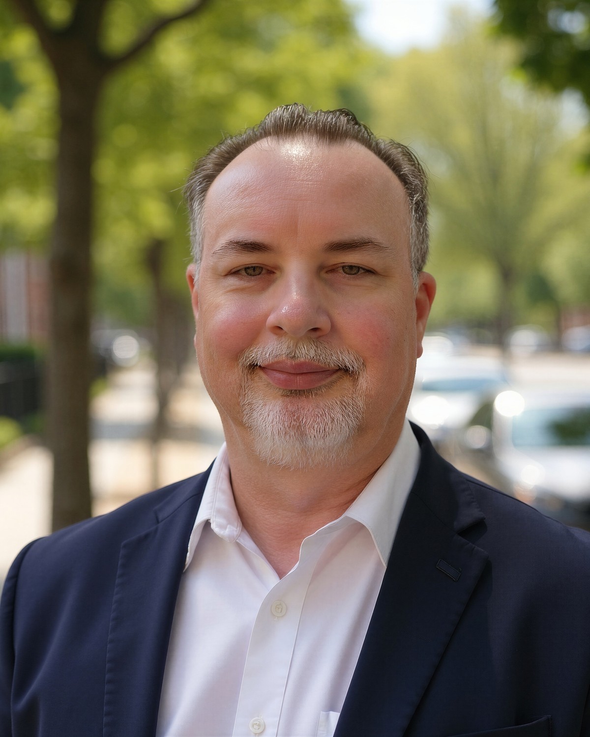 Jason, founder of Blackburn Retirement Strategies, standing outdoors on a tree-lined street.